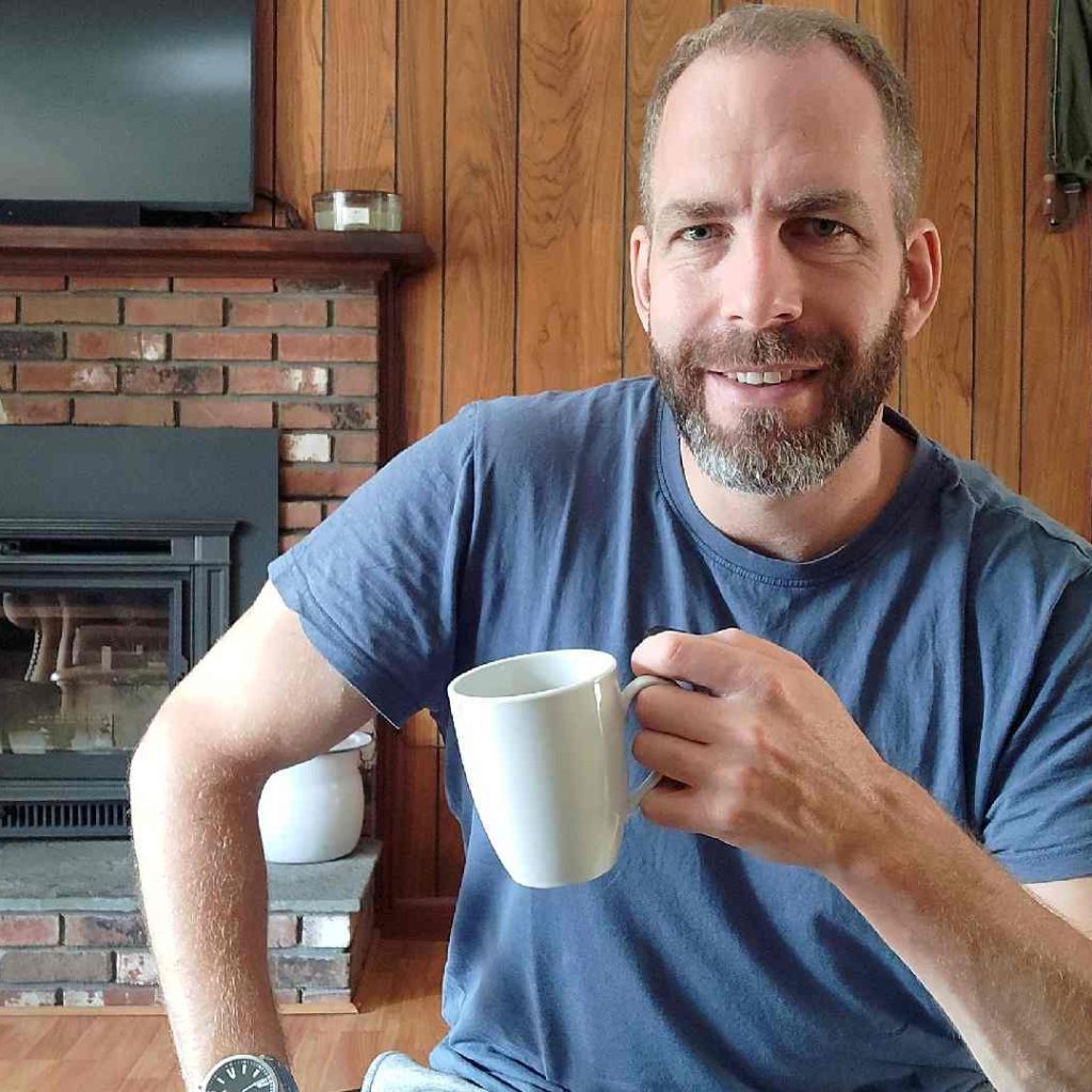 Petr pije drží hrnek kávy a usmívá se - Petr Štěpáník